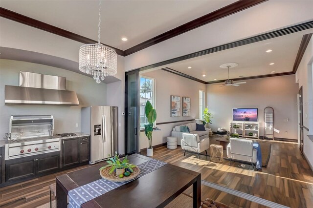 dining room featuring ceiling fan with notable chandelier, crown molding, and dark hardwood / wood-style flooring