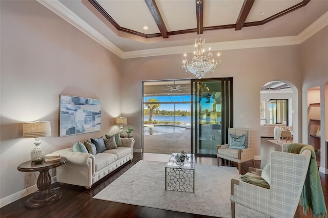 living room featuring an inviting chandelier, dark hardwood / wood-style floors, beamed ceiling, and plenty of natural light