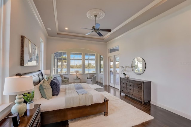 bedroom with ceiling fan, a raised ceiling, crown molding, and dark hardwood / wood-style flooring