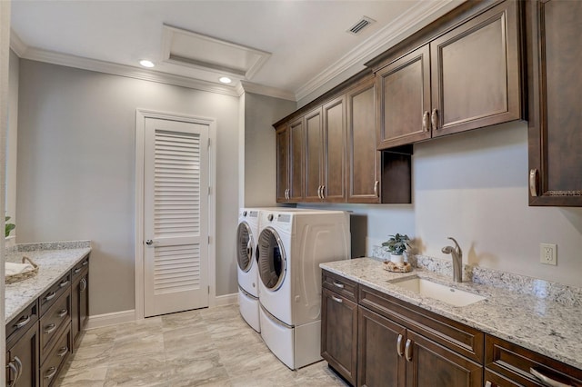 laundry area featuring cabinets, washing machine and dryer, ornamental molding, and sink