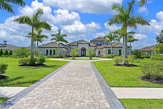 mediterranean / spanish home featuring a front lawn