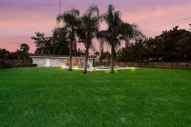 yard at dusk with a fenced in pool