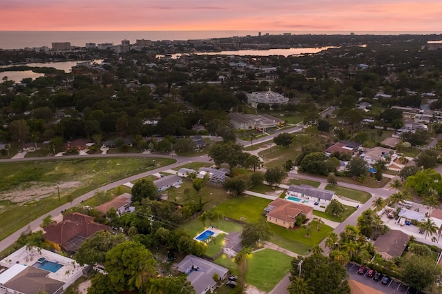 aerial view at dusk featuring a water view