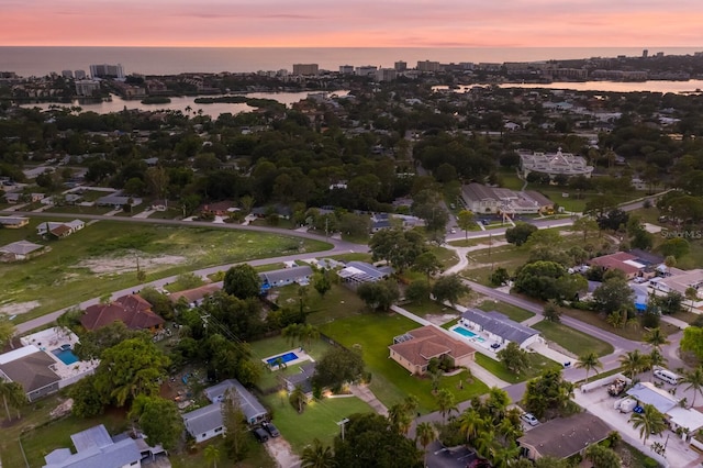 aerial view at dusk featuring a water view