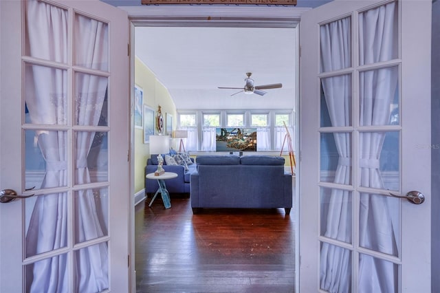 living room featuring ceiling fan, lofted ceiling, and dark wood-type flooring