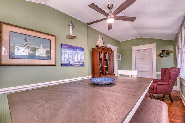 interior space featuring ceiling fan, wood-type flooring, lofted ceiling, and ornamental molding