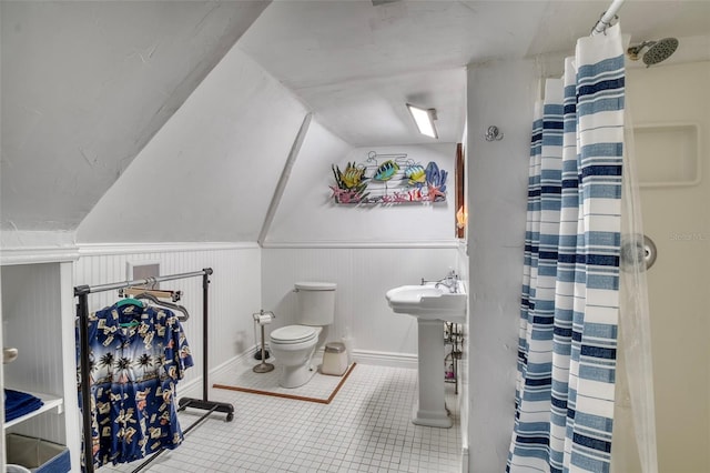 bathroom featuring tile patterned flooring, toilet, lofted ceiling, and a shower with shower curtain