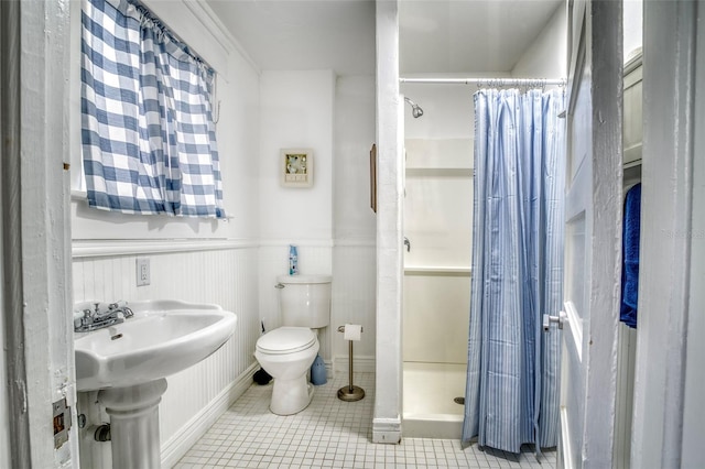 bathroom with tile patterned flooring, toilet, walk in shower, and sink