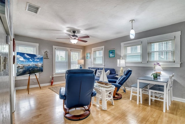 living room featuring ceiling fan, a textured ceiling, and hardwood / wood-style flooring