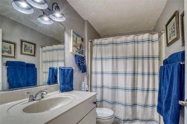 bathroom featuring a shower with curtain, vanity, a textured ceiling, and toilet