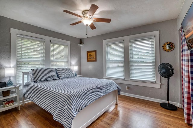 bedroom featuring ceiling fan, a textured ceiling, and light wood-type flooring