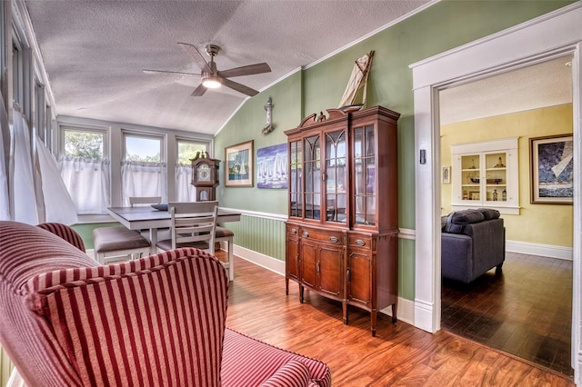 interior space with lofted ceiling, crown molding, hardwood / wood-style flooring, ceiling fan, and built in shelves