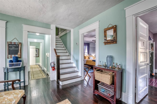 stairs with hardwood / wood-style floors, a textured ceiling, and ceiling fan