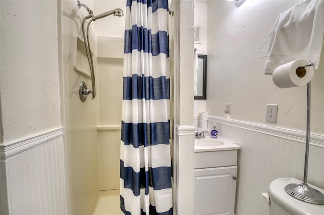 bathroom with curtained shower, vanity, and toilet