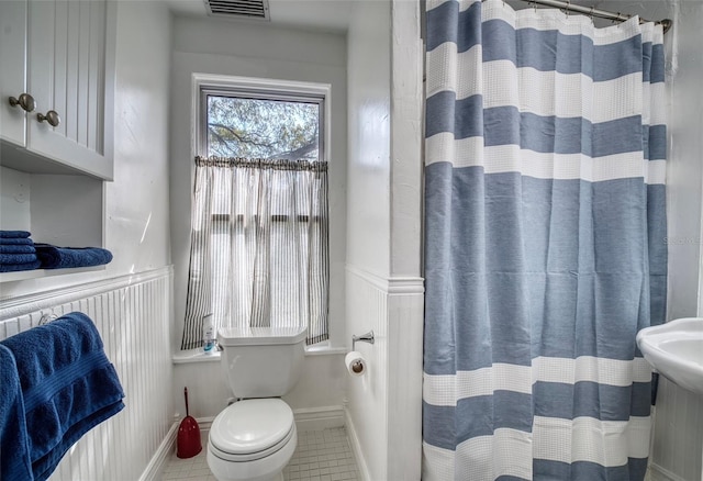 bathroom with tile patterned floors, curtained shower, and toilet