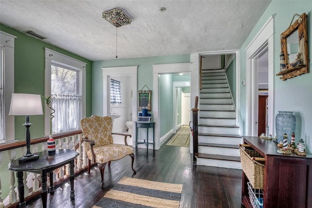 sitting room with a textured ceiling and dark hardwood / wood-style floors