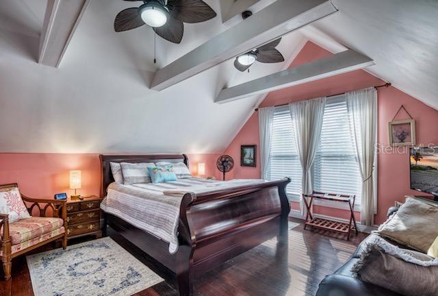 bedroom with vaulted ceiling, ceiling fan, and dark wood-type flooring