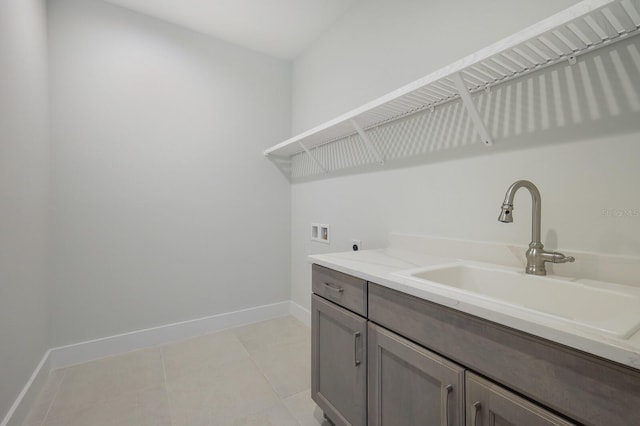 laundry area featuring washer hookup, electric dryer hookup, light tile patterned floors, and sink