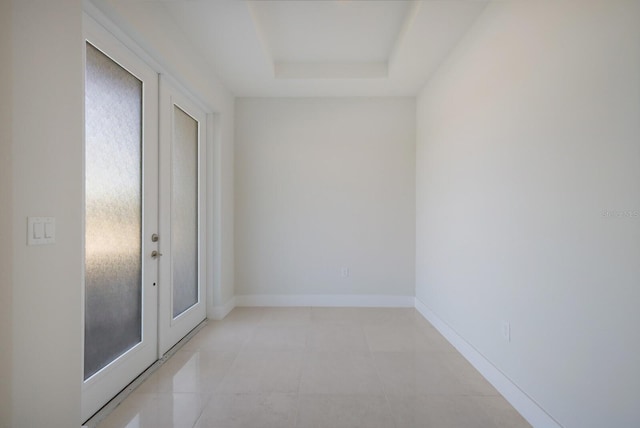 empty room with baseboards and a tray ceiling