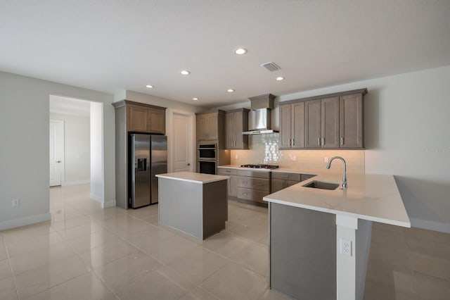 kitchen featuring sink, light tile patterned floors, wall chimney exhaust hood, backsplash, and stainless steel appliances