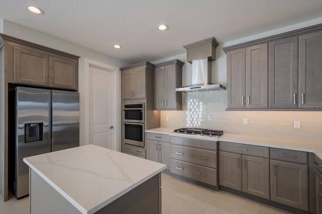 kitchen featuring appliances with stainless steel finishes, decorative backsplash, light tile patterned flooring, and a center island