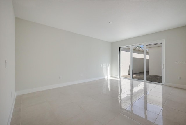 spare room with baseboards and light tile patterned flooring