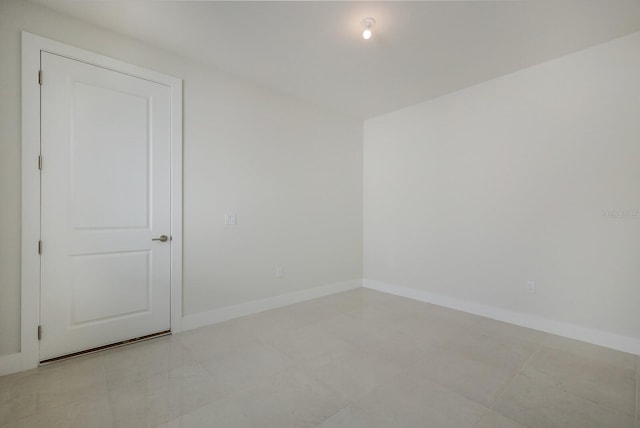 spare room with baseboards