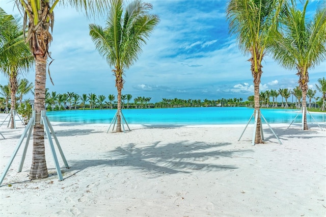 view of swimming pool featuring a beach view and a water view
