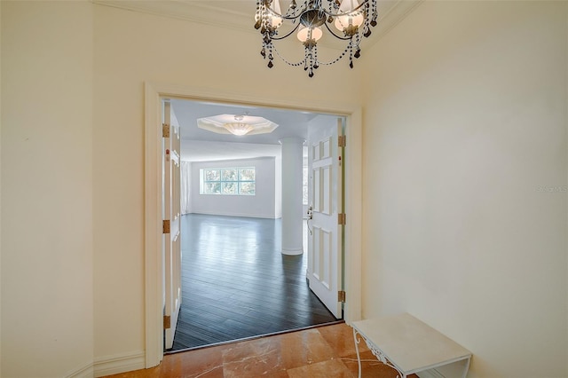 corridor with a chandelier, crown molding, and hardwood / wood-style flooring