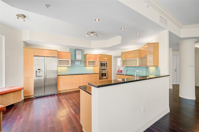 kitchen with built in appliances, tasteful backsplash, dark hardwood / wood-style flooring, a raised ceiling, and ornate columns