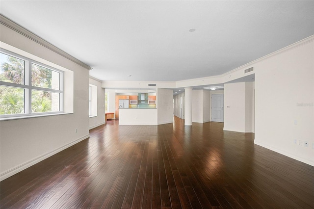 unfurnished living room featuring crown molding and dark hardwood / wood-style flooring