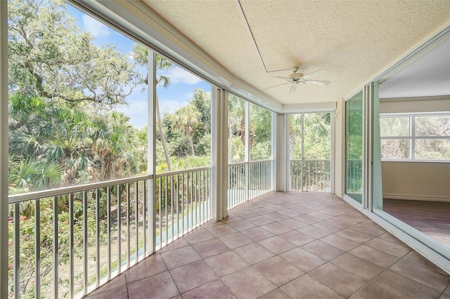 unfurnished sunroom featuring ceiling fan