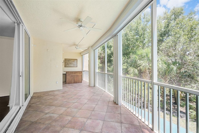 unfurnished sunroom with ceiling fan