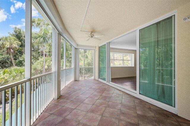 unfurnished sunroom featuring ceiling fan