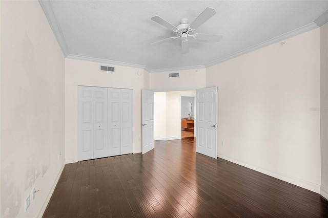 unfurnished bedroom featuring crown molding, a closet, ceiling fan, and dark hardwood / wood-style flooring