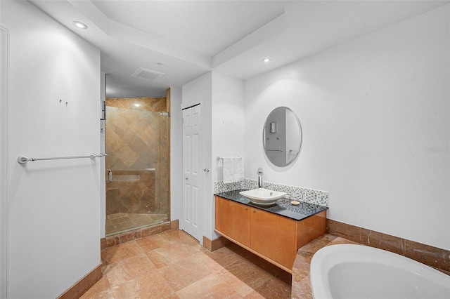 bathroom featuring tile flooring, plus walk in shower, and vanity