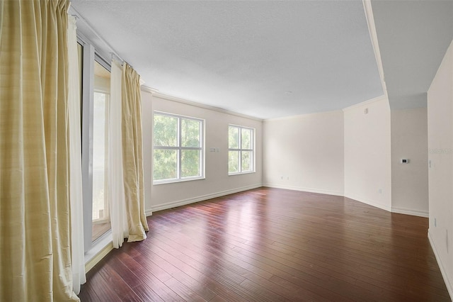 unfurnished room with crown molding, dark hardwood / wood-style flooring, and a textured ceiling