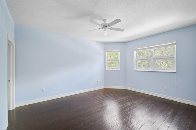 empty room featuring dark wood-type flooring, a textured ceiling, and ceiling fan