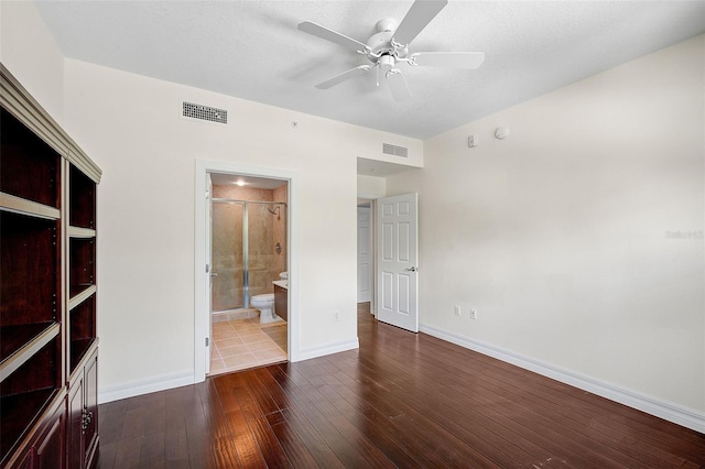 spare room with dark hardwood / wood-style flooring, a textured ceiling, and ceiling fan