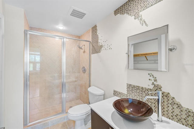 bathroom featuring vanity, tile floors, toilet, and walk in shower