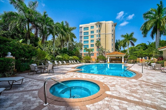 view of swimming pool featuring a community hot tub and a patio