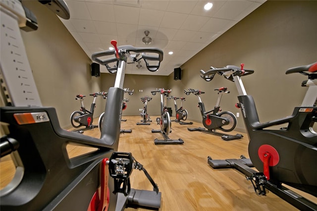 gym with a drop ceiling and wood-type flooring