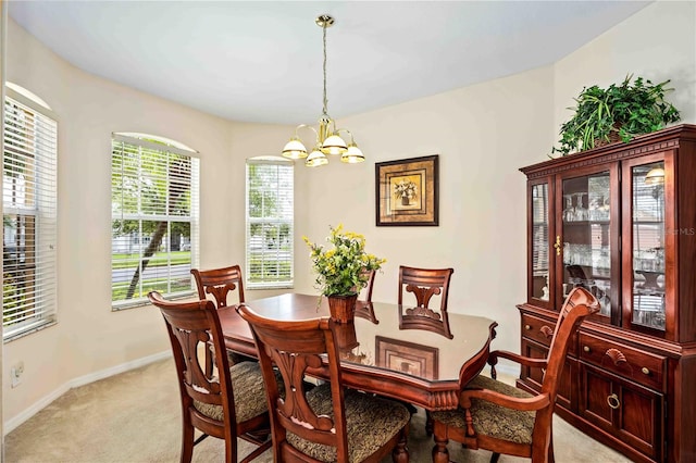 carpeted dining room with a notable chandelier