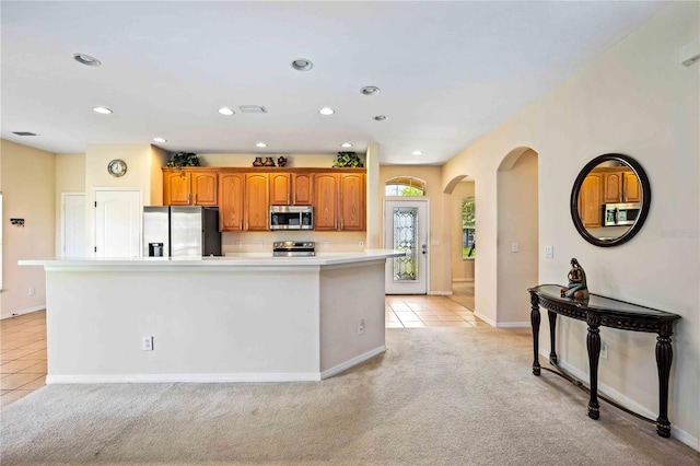 kitchen with light carpet, stainless steel appliances, and a center island