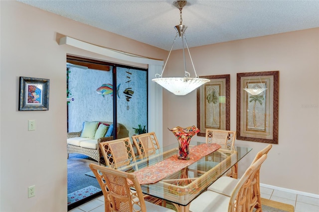 dining area featuring light tile patterned floors and a textured ceiling