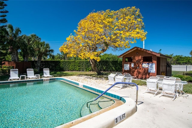 view of swimming pool featuring an outdoor structure and a patio