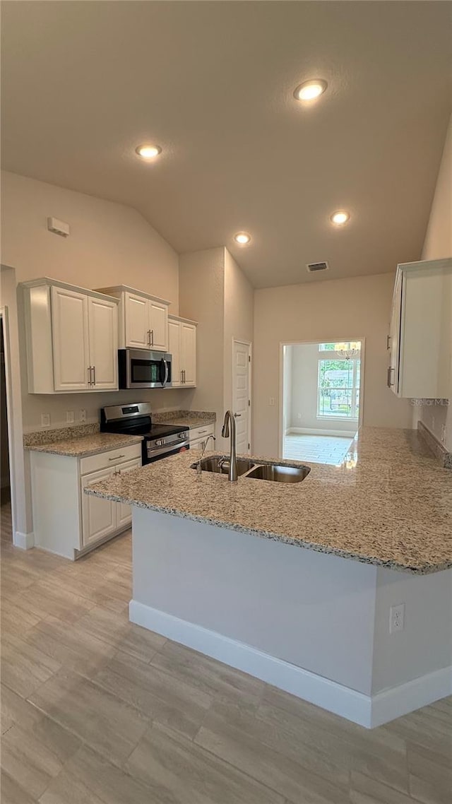 kitchen with sink, kitchen peninsula, white cabinets, and appliances with stainless steel finishes