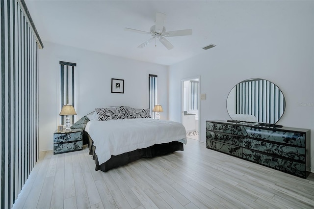 bedroom featuring ensuite bath, light hardwood / wood-style floors, and ceiling fan