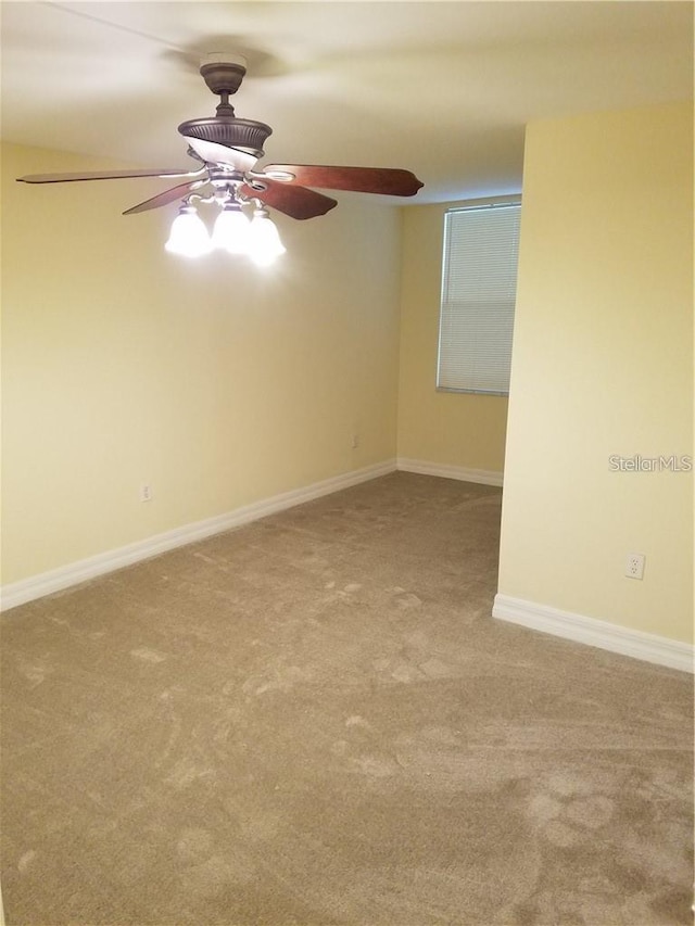 carpeted spare room with ceiling fan