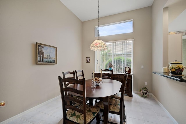 dining room featuring high vaulted ceiling and light tile flooring